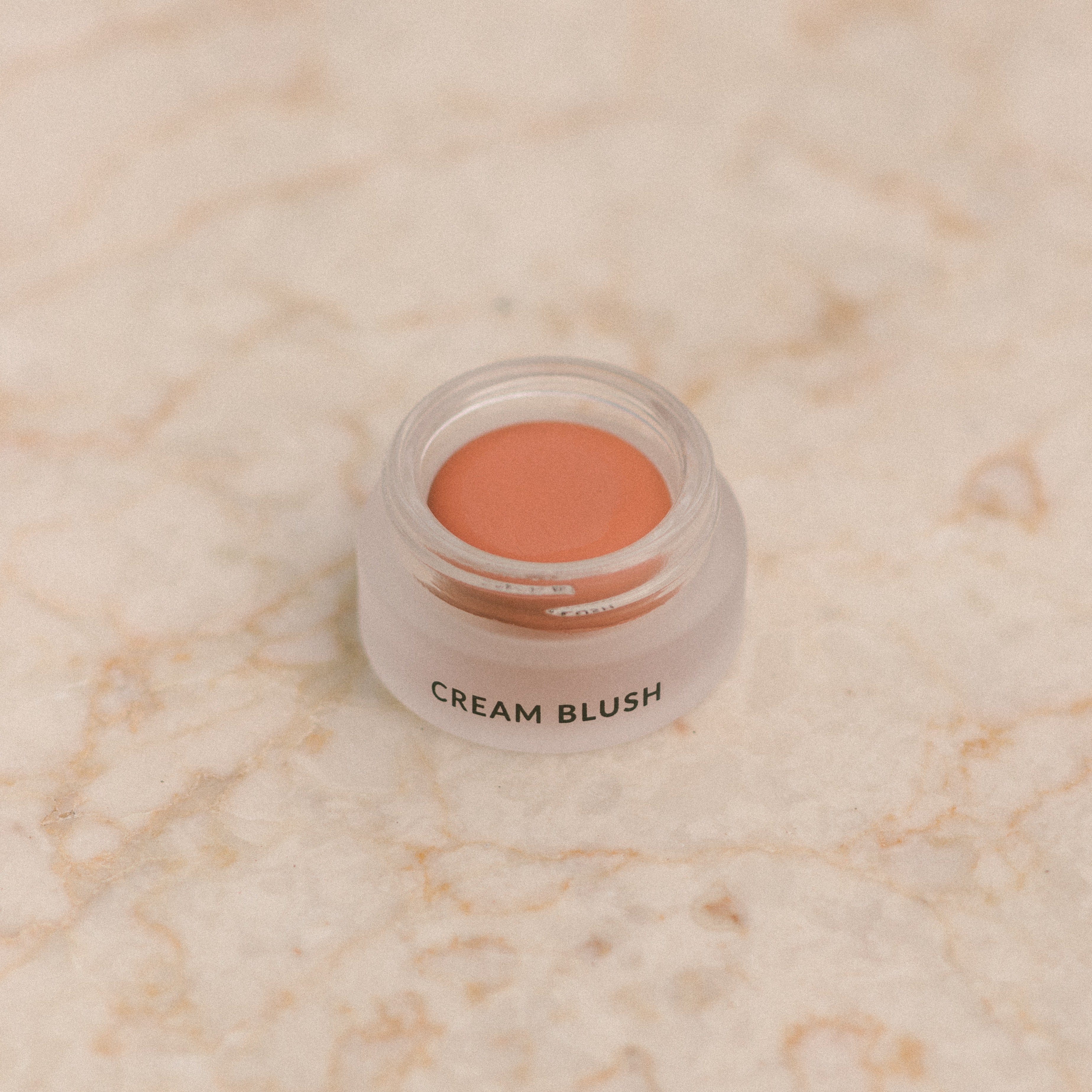 Eco By Sonya Cream Blush natural makeup in glass jar showing colour and soft texture on marble background.