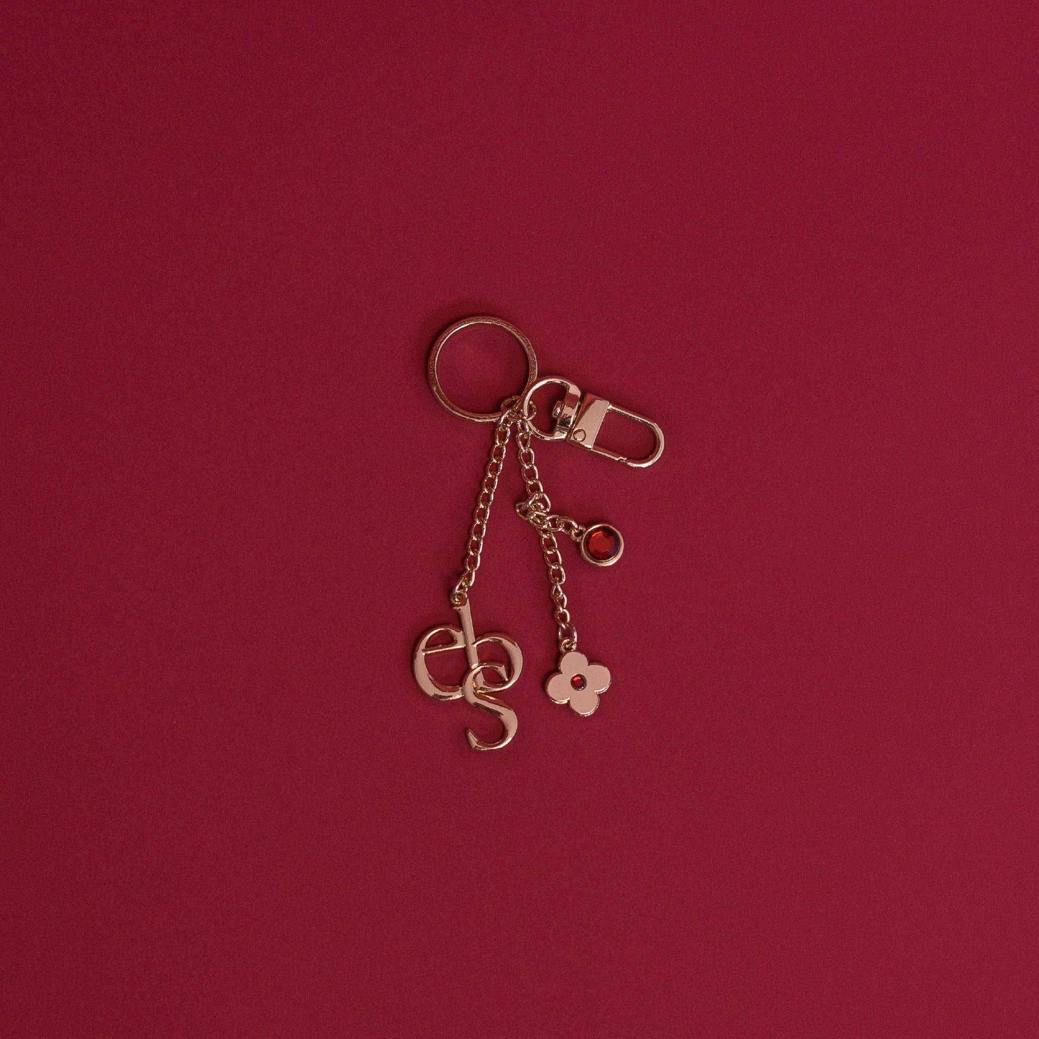 A gold charm on a deep red background.