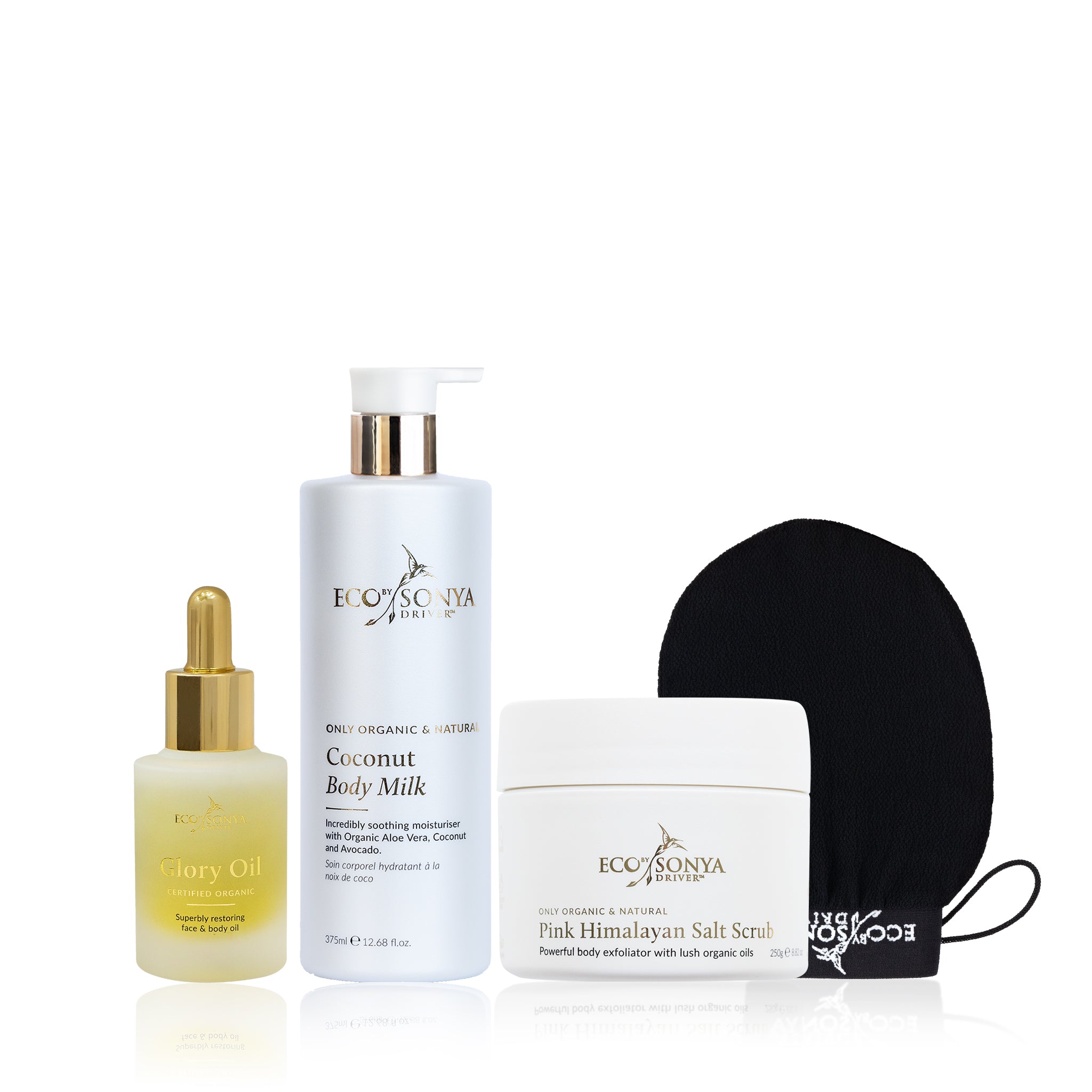 Set of Eco by Sonya skincare products including glory oil, body milk, salt scrub, and mitt on a white background.